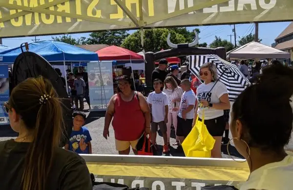 Families gathering at Attorney Dean Boyd’s booth during a community festival in Texas.