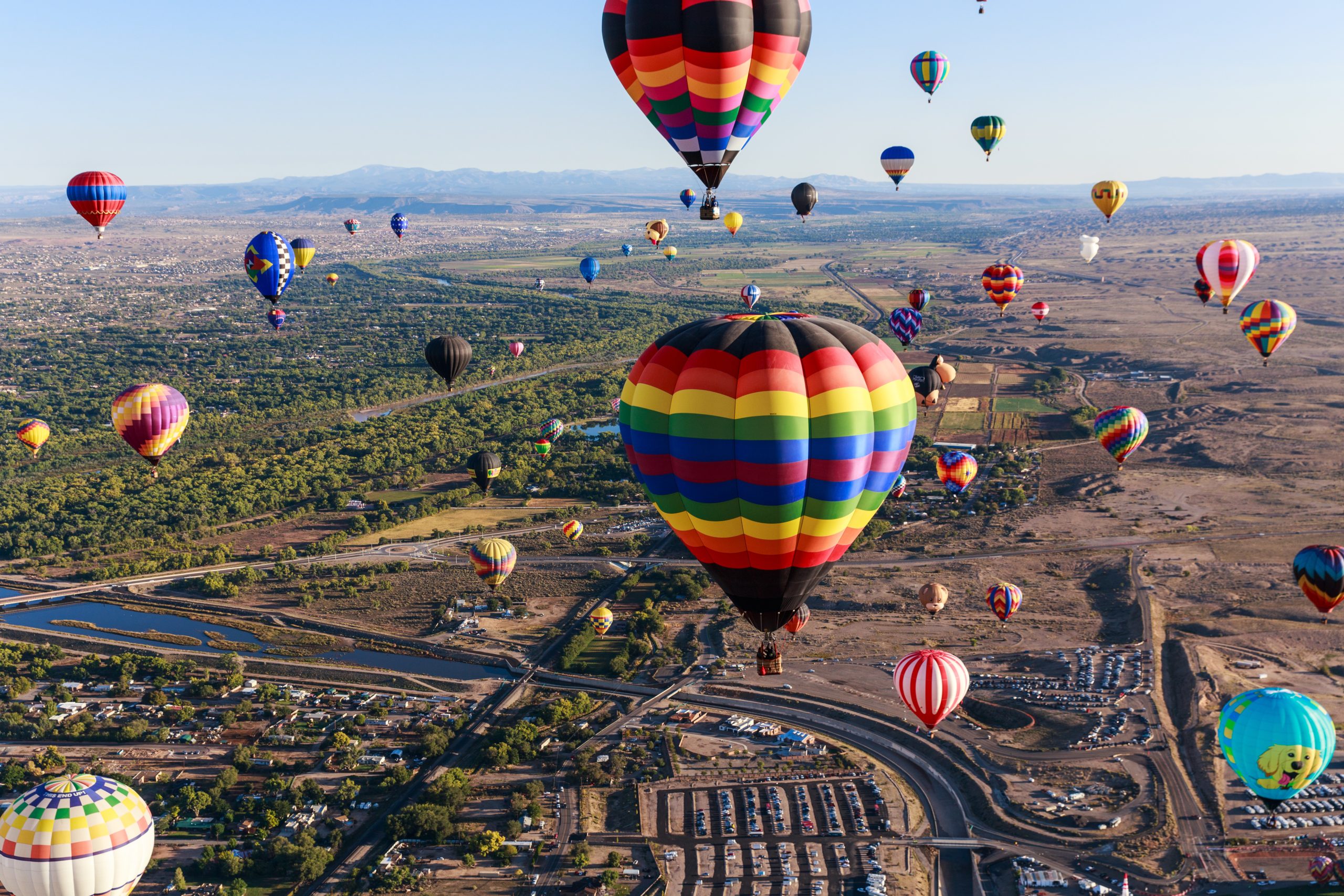 Colorful hot air balloons float above the city during the ExxonMobil Albuquerque International Balloon Fiesta.